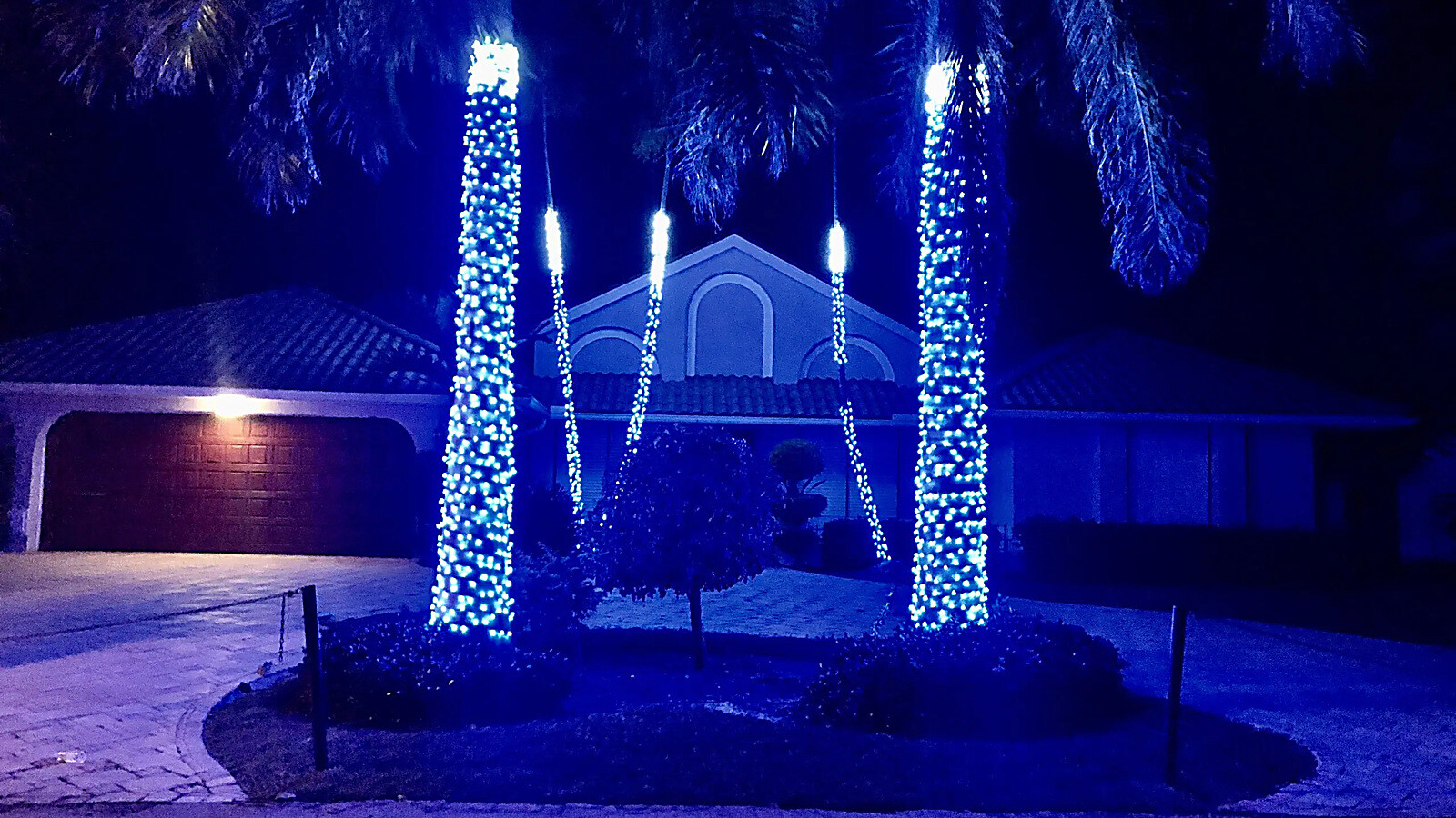 A home and street beautifully lit for Christmas at night